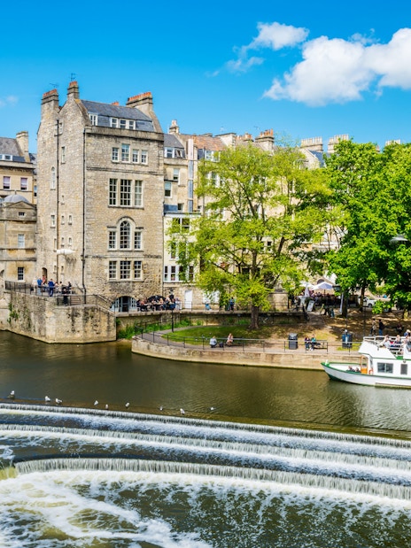 Bridgerton tour group on Bath city street with historic architecture and live music performance.