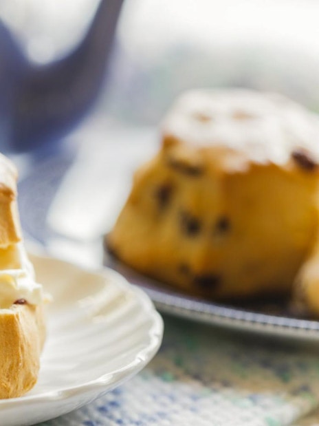 Lake District cruise boat on serene water with lush hills, part of London day tour with cream tea.