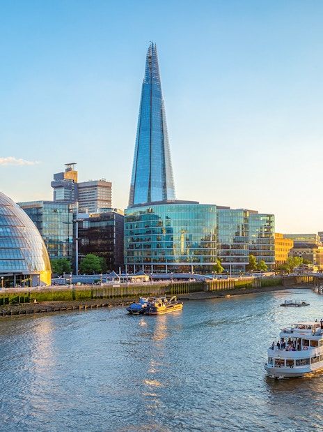 Tootbus passing London Eye and Big Ben, offering Hop-On-Hop-Off Bus Tour with Thames River Cruise.