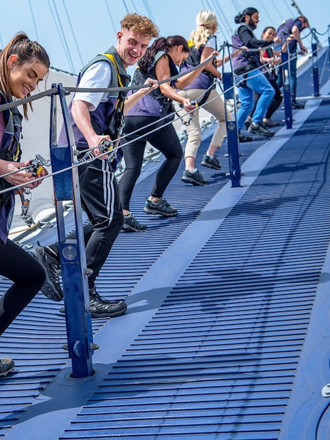 Visitors ascending the O2 Arena summit in London with panoramic city views.