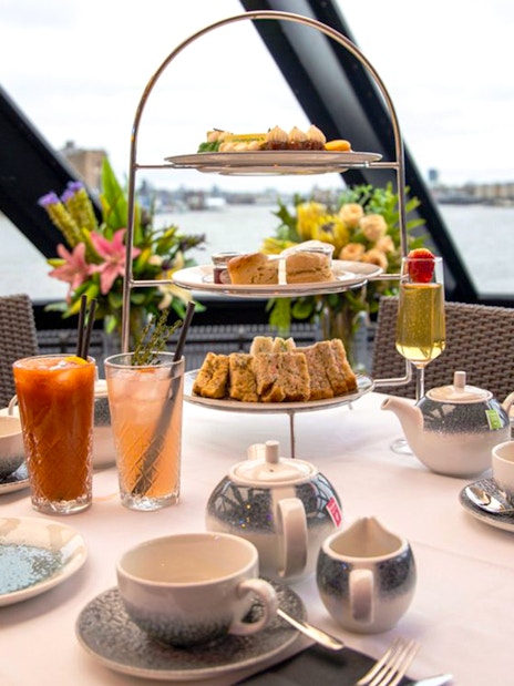 Thames Afternoon Tea Cruise table with tea set and pastries.