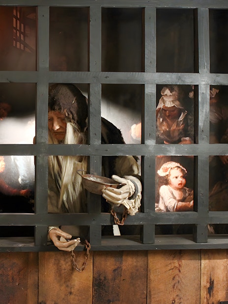 Visitors exploring The Clink Prison Museum in London, viewing historical prison artifacts.