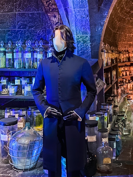 Visitors exploring costume exhibit at Harry Potter London tours, featuring iconic wizard robes and props.