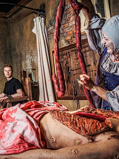 Visitors exploring the London Dungeon's eerie corridors as part of the VIP package experience.