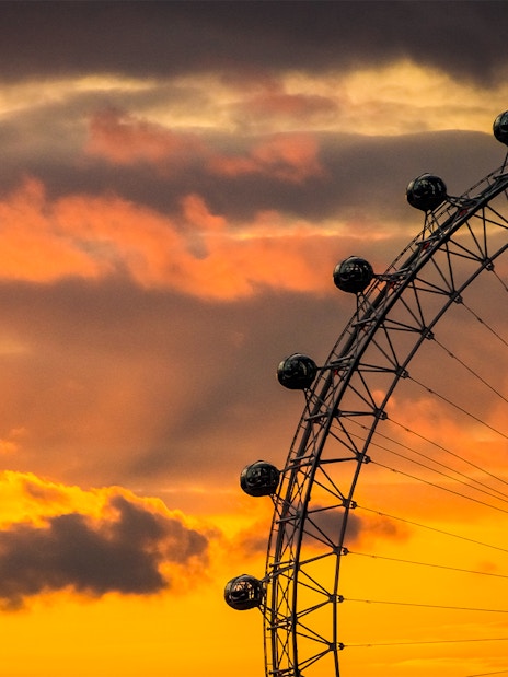 London Eye overlooking the Thames River at sunset in London, England.