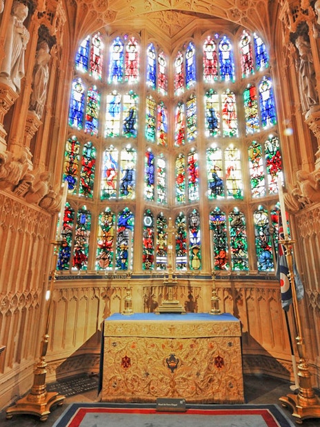 Stained glass windows inside Westminster Abbey, London, showcasing intricate historical designs.