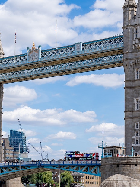 Tootbus driving past Big Ben and London Eye, offering Hop-On-Hop-Off tour with Thames River Cruise.