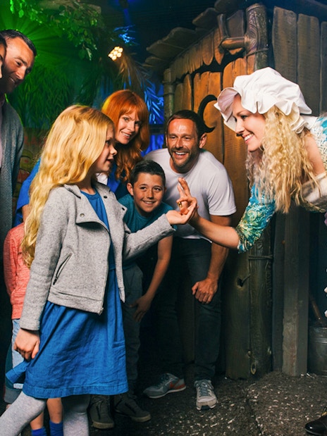 Visitors enjoying the Shrek's Adventure! London tour, featuring interactive exhibits and fun-filled activities for families