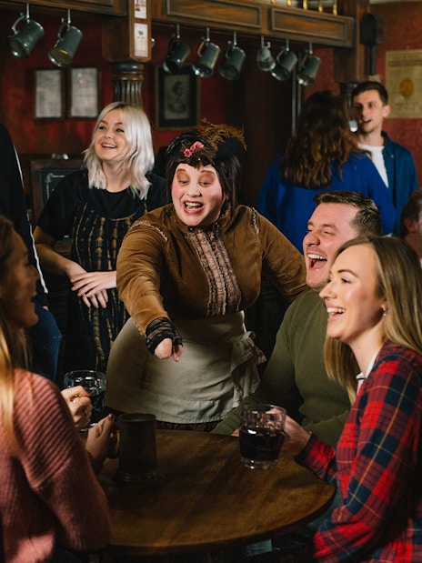 Visitors enjoying drinks at the London Dungeon Tavern, a themed historical attraction in London.