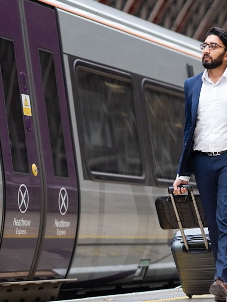 Passengers boarding Heathrow Express train at Heathrow Airport for transfer to London Paddington.