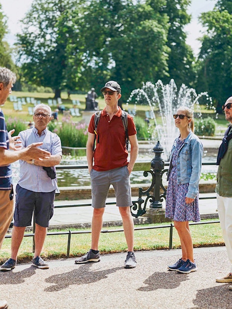 Kensington Palace garden view with visitors and guide