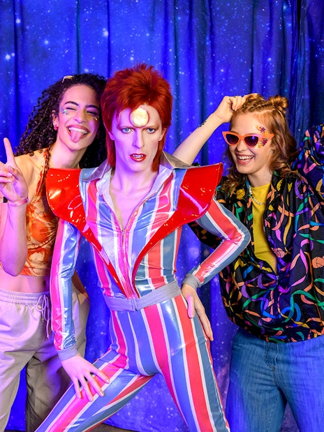 Tourists posing with David Bowie wax figure at Madame Tussauds London, part of the limited time Harry Potter Warner Bros. Studio Tour combo offer