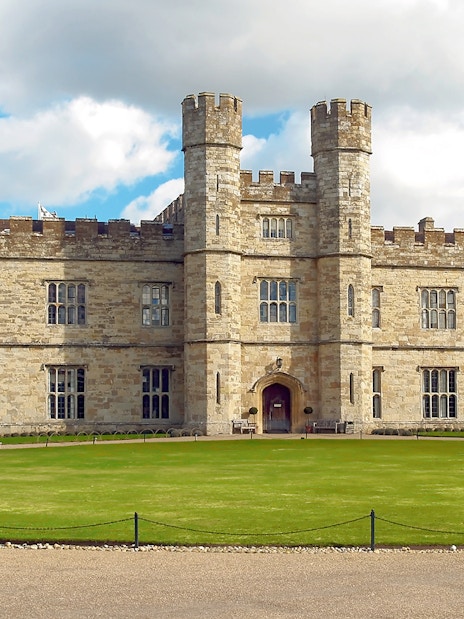 Leeds Castle with moat and gardens on a sunny day in Kent, England.