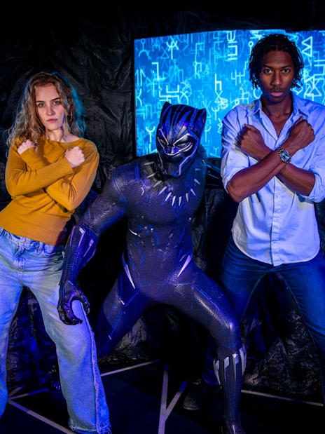 Black Panther wax figure at Madame Tussauds London with visitors taking photos.