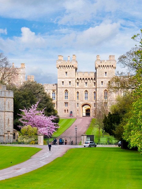 Windsor Castle exterior with tourists exploring the historic site in England.