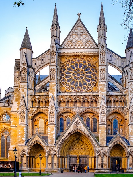 Northern entrance of Westminster Abbey with tourists entering for a guided tour in London.