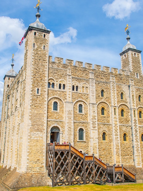 White Tower at the Tower of London with tourists exploring the historic site.