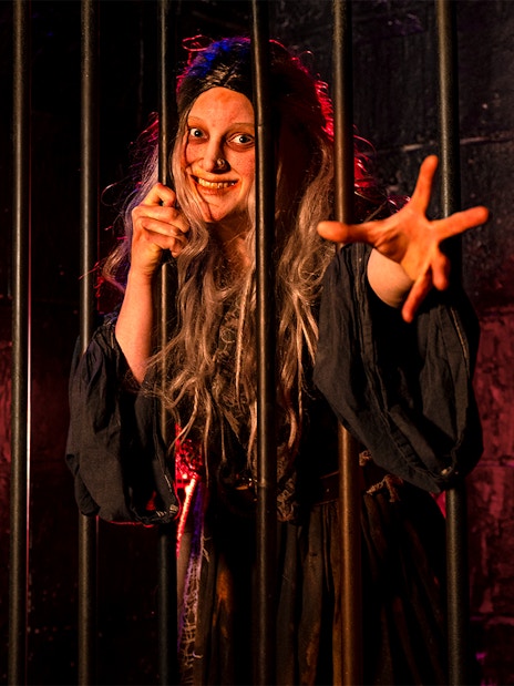 Witches role play in London Dungeon with actors in period costumes performing a historical scene.