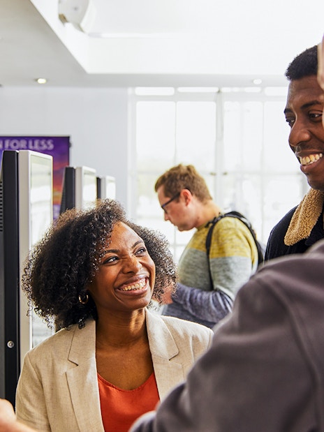 Guide assisting tourist at London Eye ticket office in London, England.