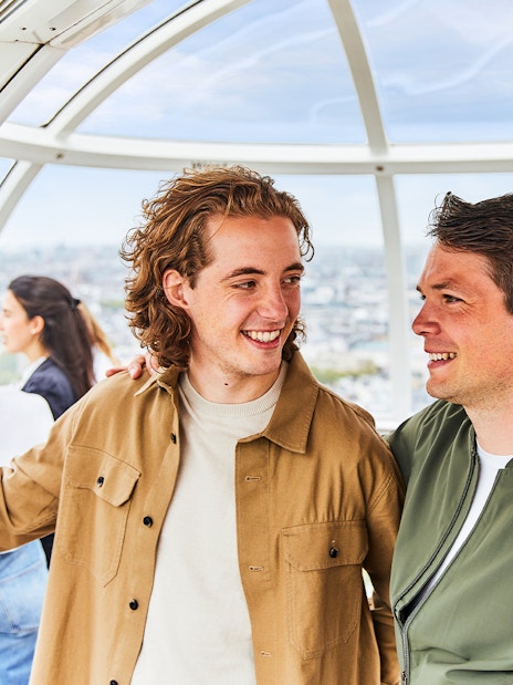 Visitors boarding the London Eye capsule with fast track tickets, overlooking the Thames River.
