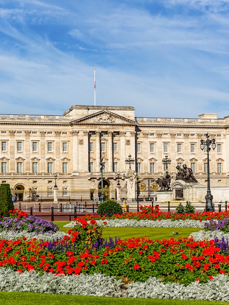 Buckingham Palace with iconic red double-decker bus on London hop-on hop-off tour.