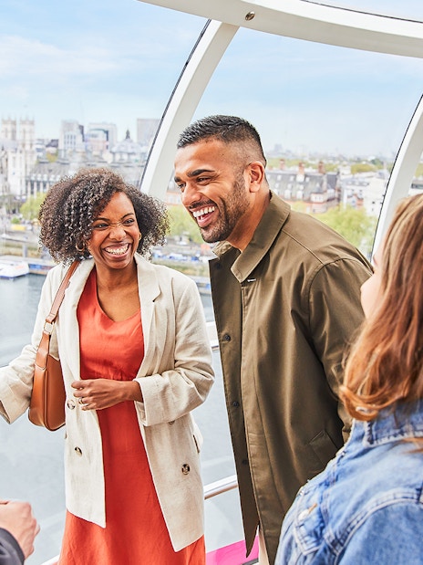 London Eye capsule interior with passengers enjoying panoramic city views.