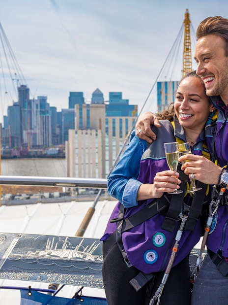 Participants enjoy champagne atop The O2 Arena in London with panoramic city views.