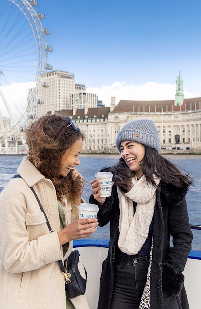 London Eye view from River Thames cruise with iconic red double-decker bus.