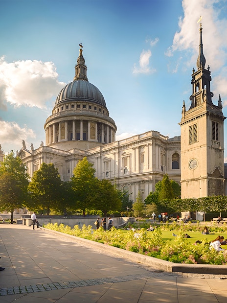 St. Paul's Cathedral in London with tourists exploring the exterior architecture.
