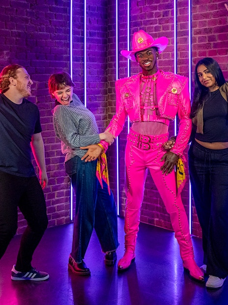 Lil Nas X wax figure at Madame Tussauds London in a vibrant outfit.